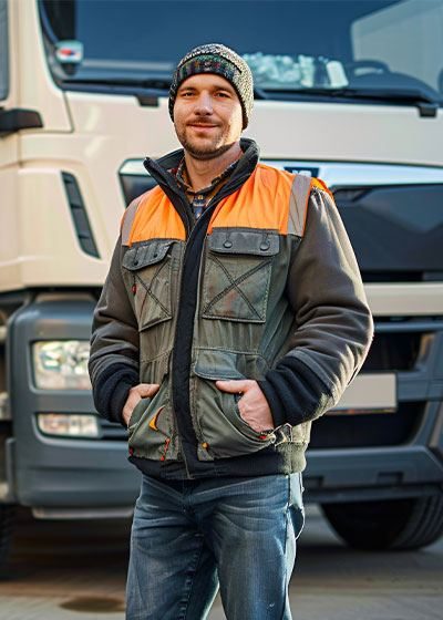 Ocean AA Trucking driver in a high-visibility jacket standing in front of a truck